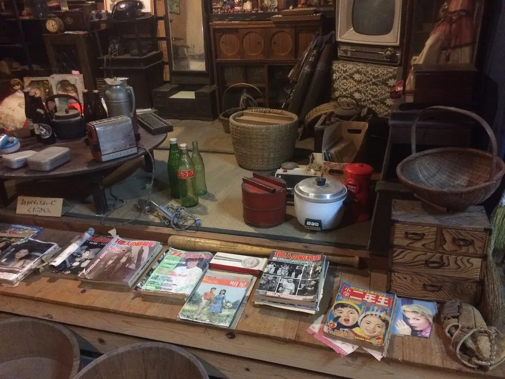 古道具や雑誌が積まれた片付け前の部屋