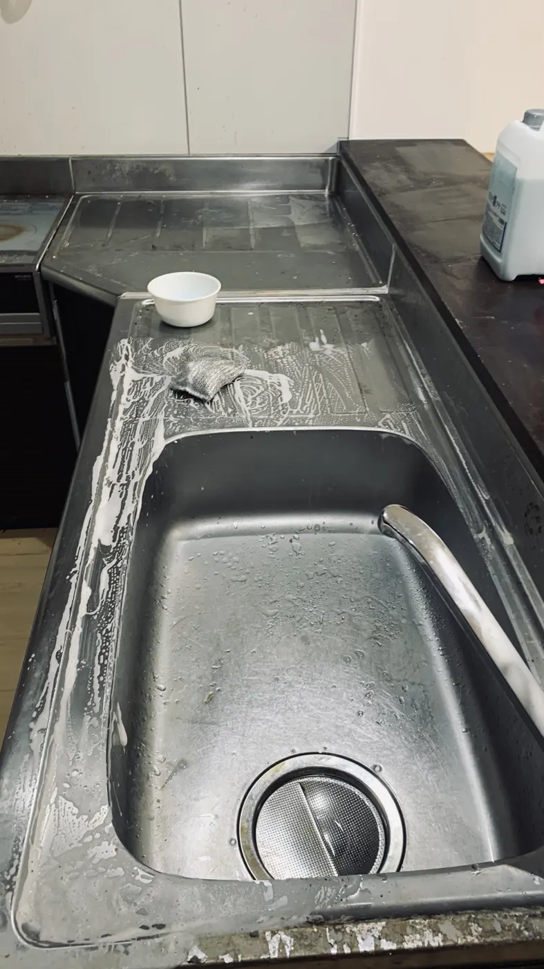 洗剤を塗ってスポンジでこすっている途中のステンレスのシンク
